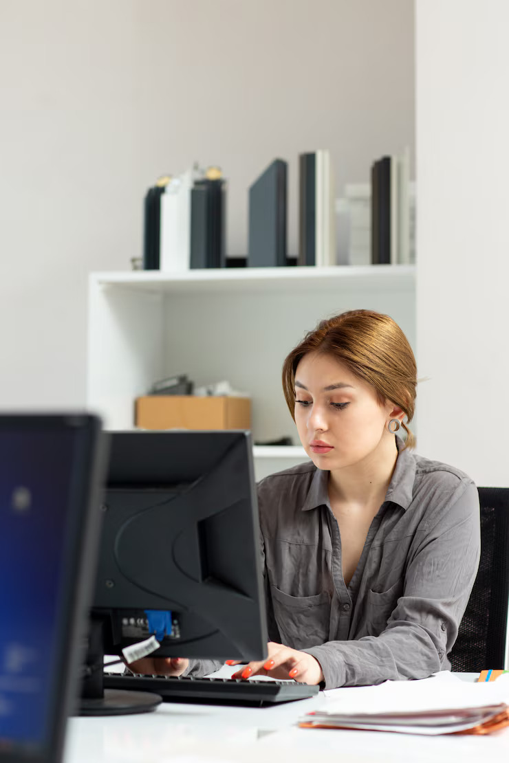front-view-young-beautiful-lady-grey-shirt-working-her-pc-sitting-inside-her-office-daytime-building-job-activity_140725-15134